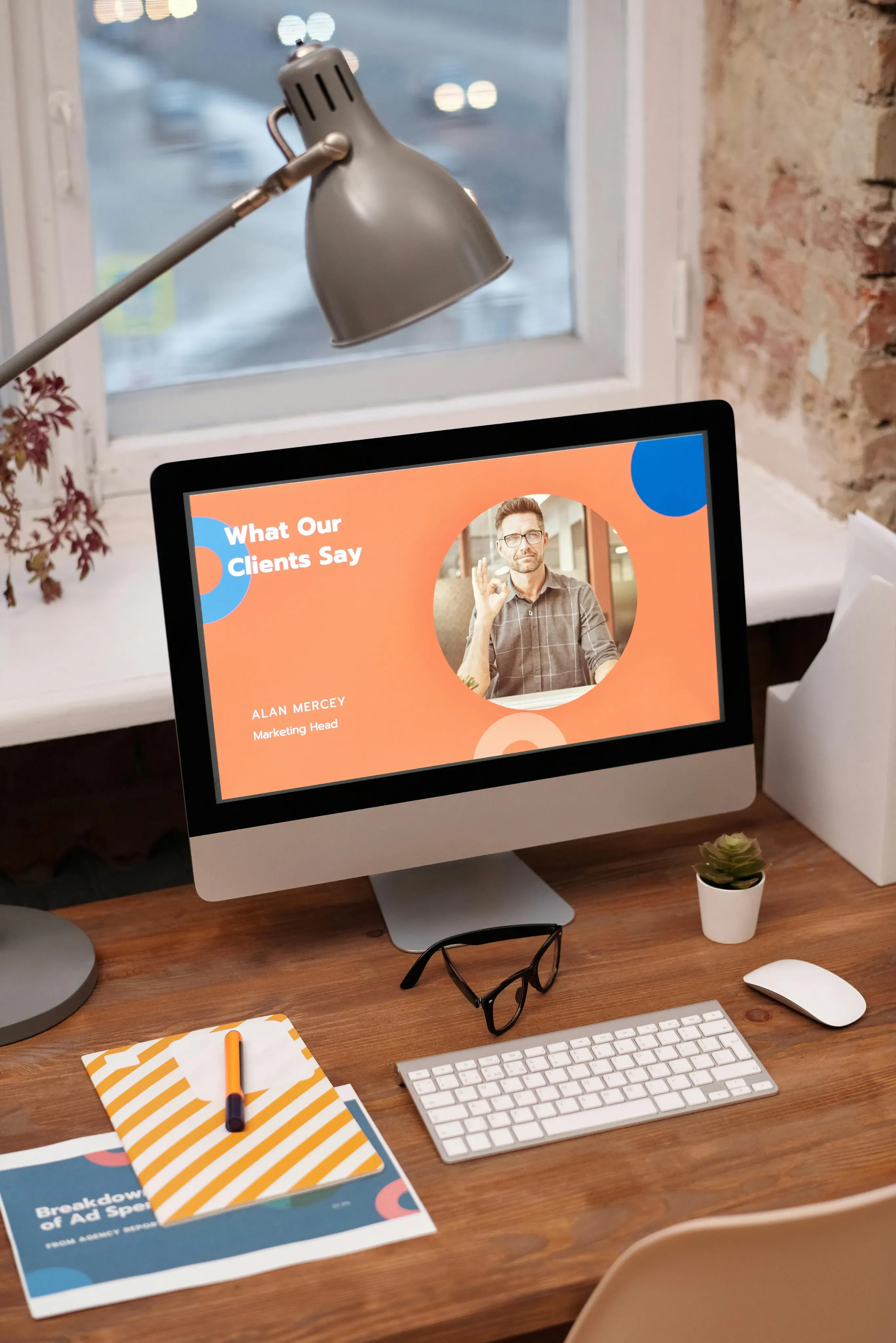 Desktop computer on a desk showing a “What Our Clients Say” presentation slide